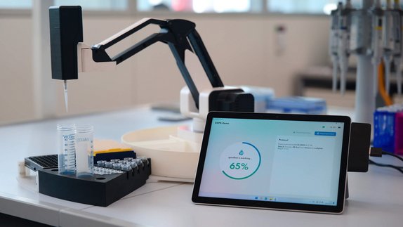 Der Roboterarm mit Pipette von der goodBot UG befüllt ein Reagenzglas mit Flüssigkeit.