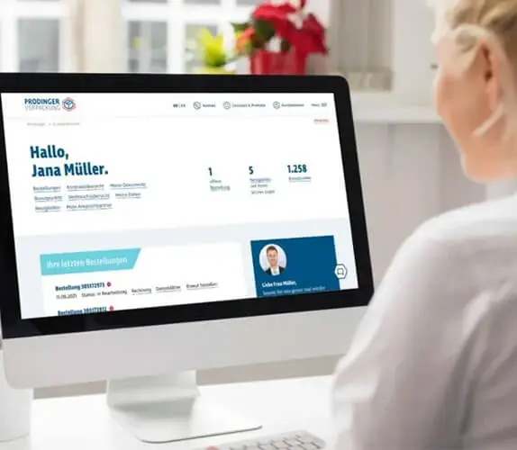 Eine Frau sitzt vor dem Computer uns kauft im Shop der PRODINGER Verpackung ein.