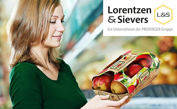 Eine Frau steht im Supermarkt und betrachtet eine Obstverpackung mit Äpfeln.