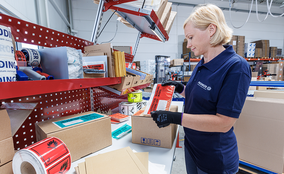 Packtisch ausgestattet mit diversen Versandtaschen, Etiketten und Lieferscheinhüllen.